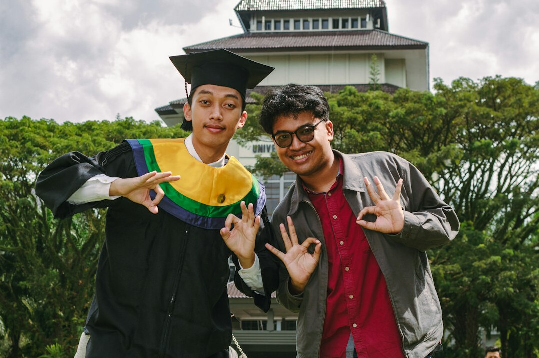Two Japanese adult students celebrating after finishing a finance course